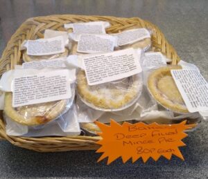 Individual baked deep-filled mince pies in a basket on the counter at Radley Village Shop