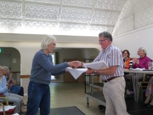 Bob Earl, as chairman, presenting 15-year certificates to long-serving volunteers at Radley Village Shop at the AGM of The Radley Village Shop Association Limited in Radley VIllage Hall on 1 June 2022